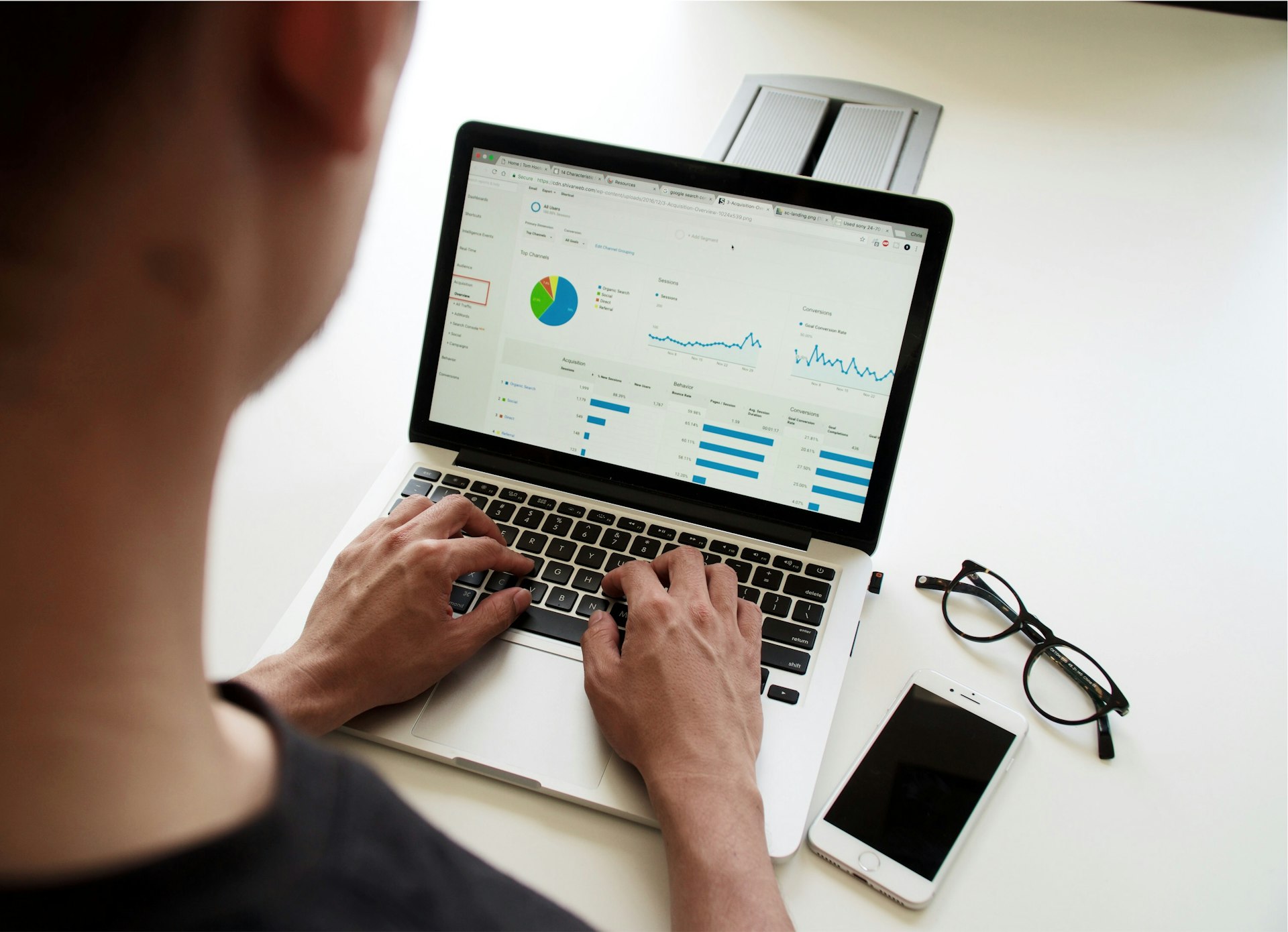 Business analyst reviewing technology costs and performance data on a laptop